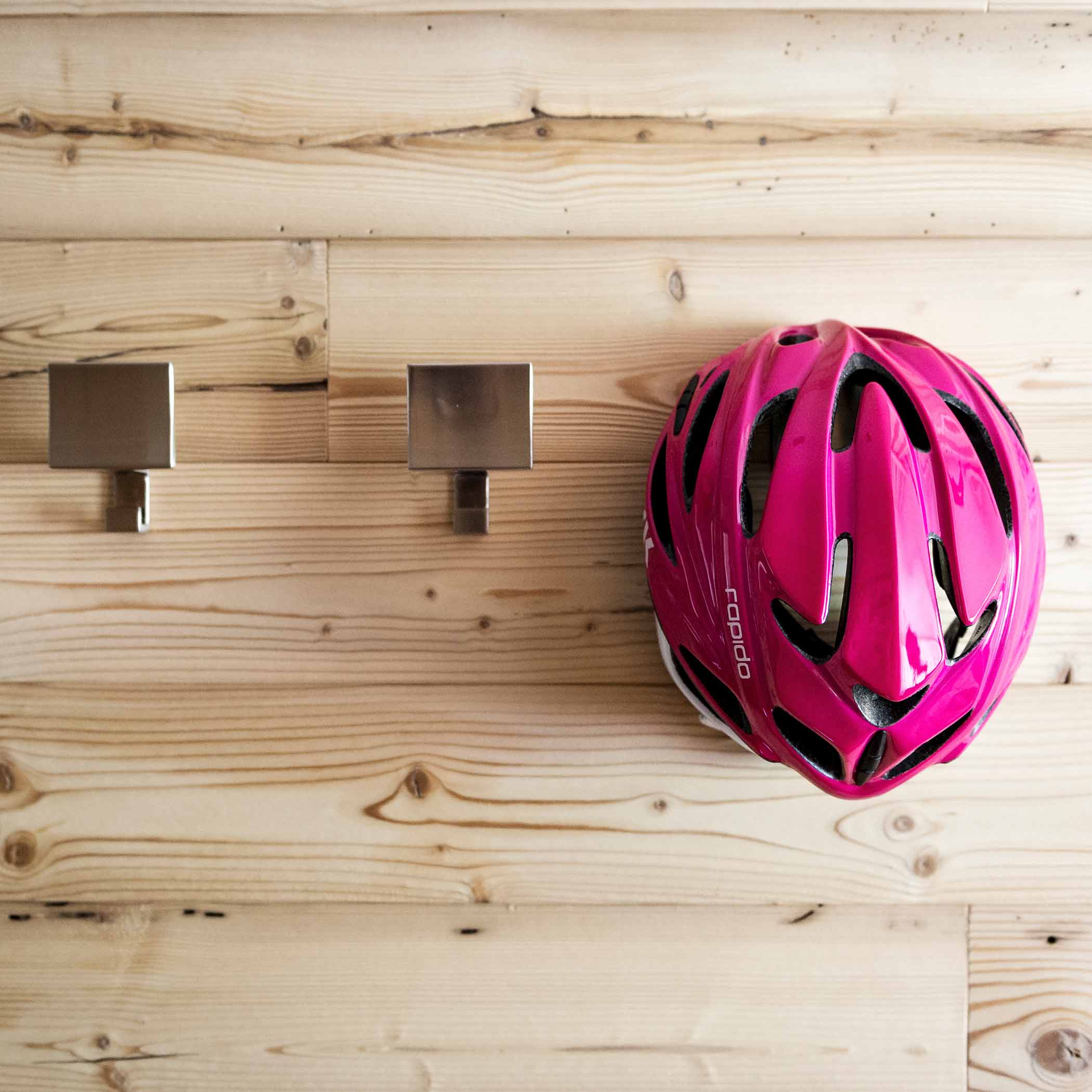 Holzwand mit pinkem Fahrradhelm | Hotel Störes